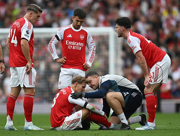 Arsenal vs Leeds Review: Martin Odegaard with the Arsenal Physio, Simon Murphy, during the Premier League match between Arsenal and Leeds at the Emirates Stadium on August 23, 2025.