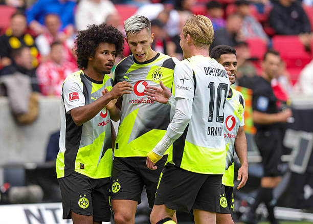 Bundesliga Roundup, Matchday 5: Karim Adeyemi celebrates his goal with Nico Schlotterbeck and Julian Brandt during the Bundesliga match between Mainz 05 and Dortmund at MEWA Arena on September 27, 2025.