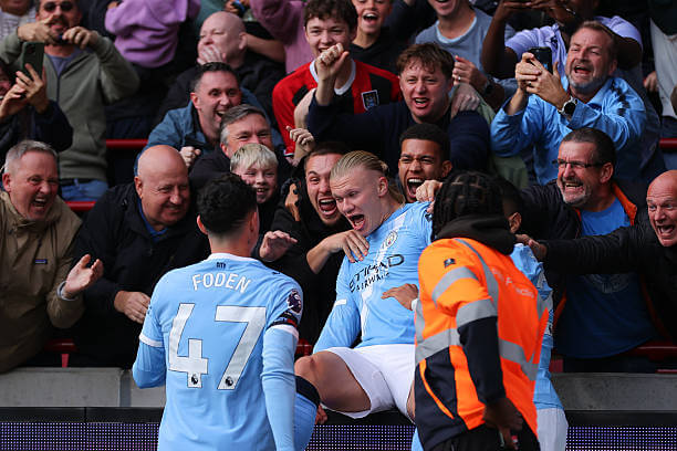 Premier League Roundup, Matchday 7: Erling Haaland almost falls backward off the advertising hoardings as he celebrates his goal during the Premier League match between Brentford and Manchester City at Gtech Community Stadium on October 05, 2025.